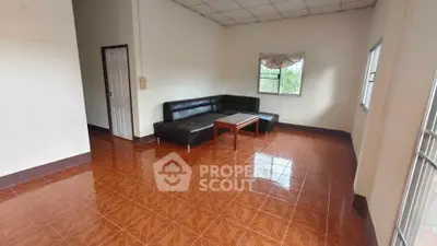 Spacious living room with tiled floor and black leather sectional sofa