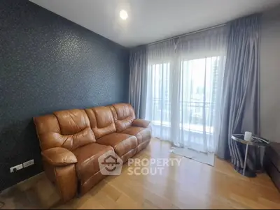 Modern living room with leather sofa and large windows in high-rise apartment
