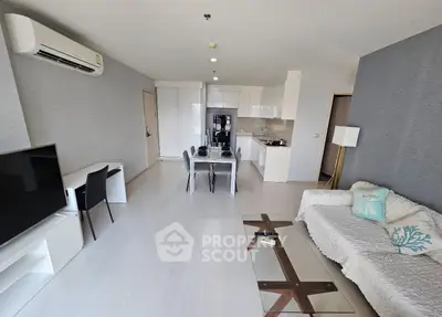 Modern living room with open kitchen, sleek furniture, and stylish decor