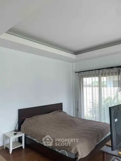 Cozy bedroom with natural light and modern furnishings, perfect for relaxation.
