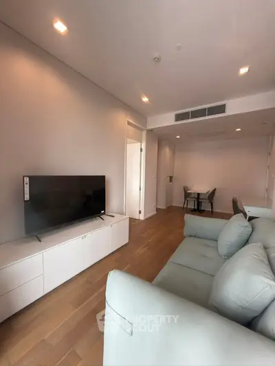 Modern living room with sleek furniture and wooden flooring in a stylish apartment.