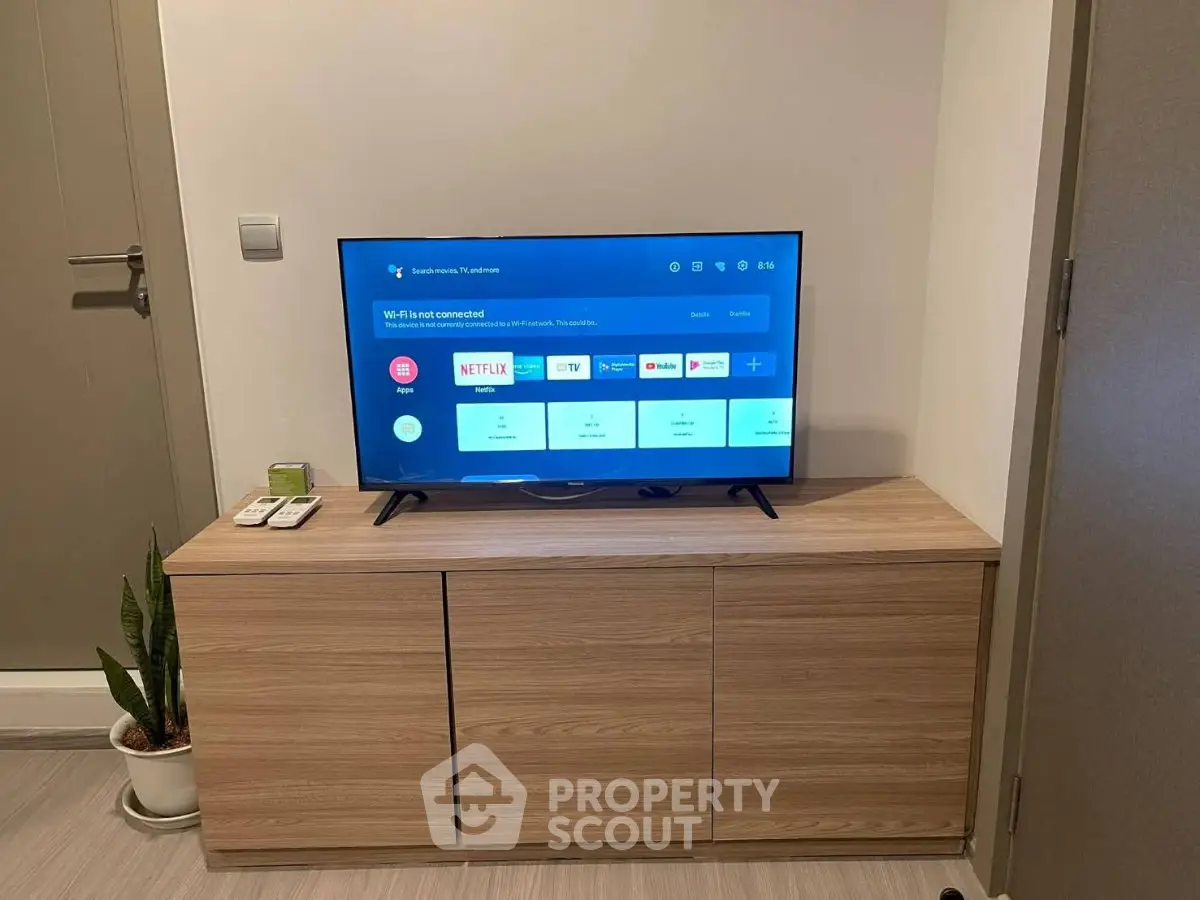 Modern living room with sleek TV setup on wooden cabinet, perfect for entertainment.