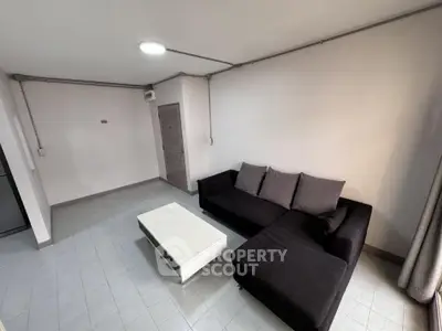Modern living room with sleek black sofa and minimalist coffee table.