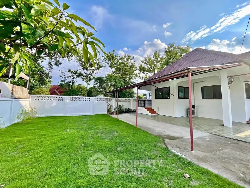 Charming single-story home with spacious green lawn and covered patio, perfect for outdoor relaxation.