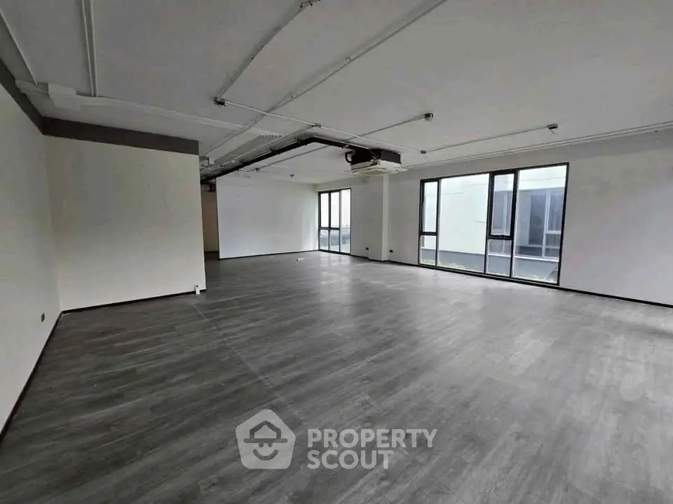 Spacious modern living room with large windows and sleek flooring