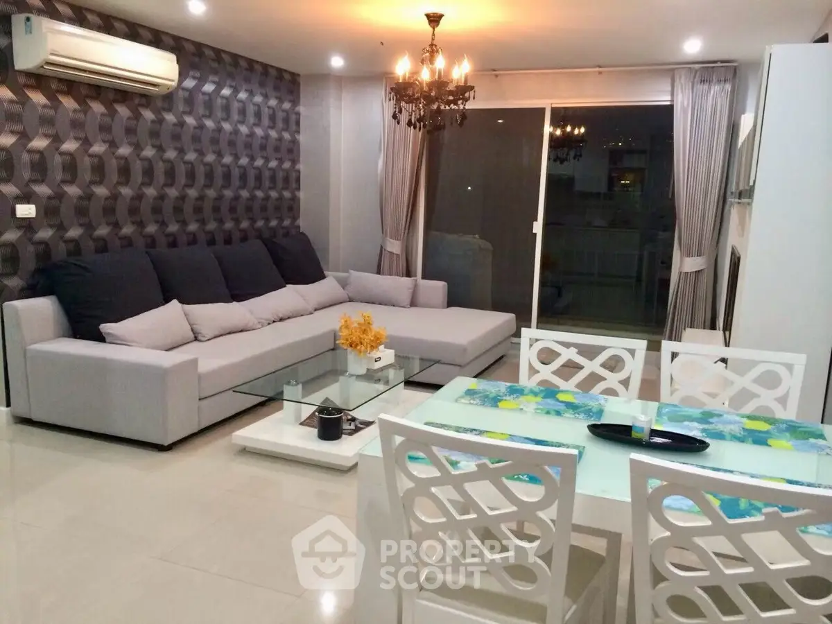 Elegant living room with modern decor, spacious seating, and stylish chandelier lighting.