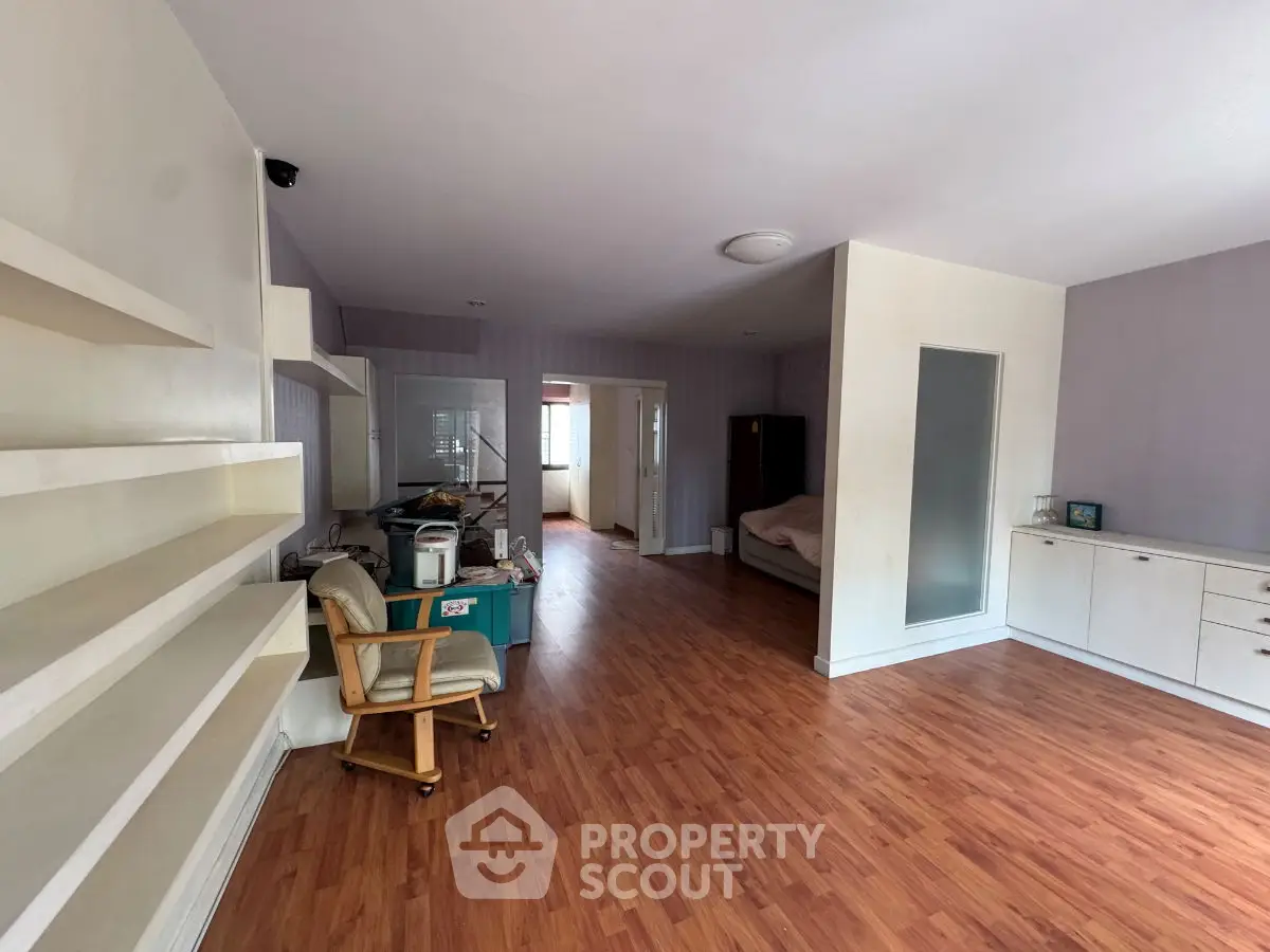 Spacious living area with wooden flooring and built-in shelves