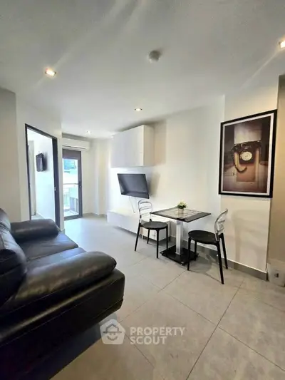 Modern living room with sleek furniture and wall-mounted TV in a stylish apartment.