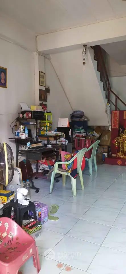 Cozy living space with eclectic decor and staircase, ideal for creative setups.
