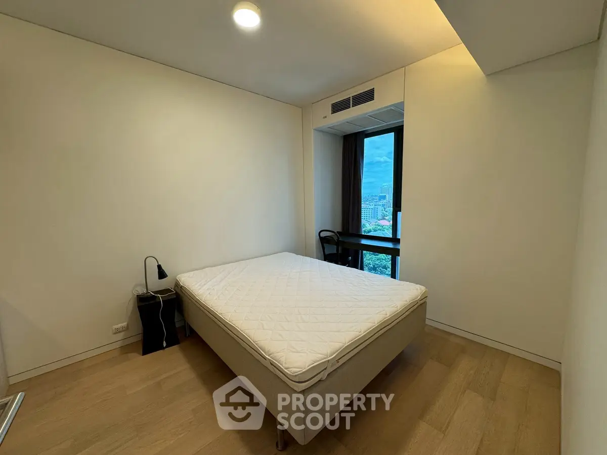 Modern minimalist bedroom with city view and natural light
