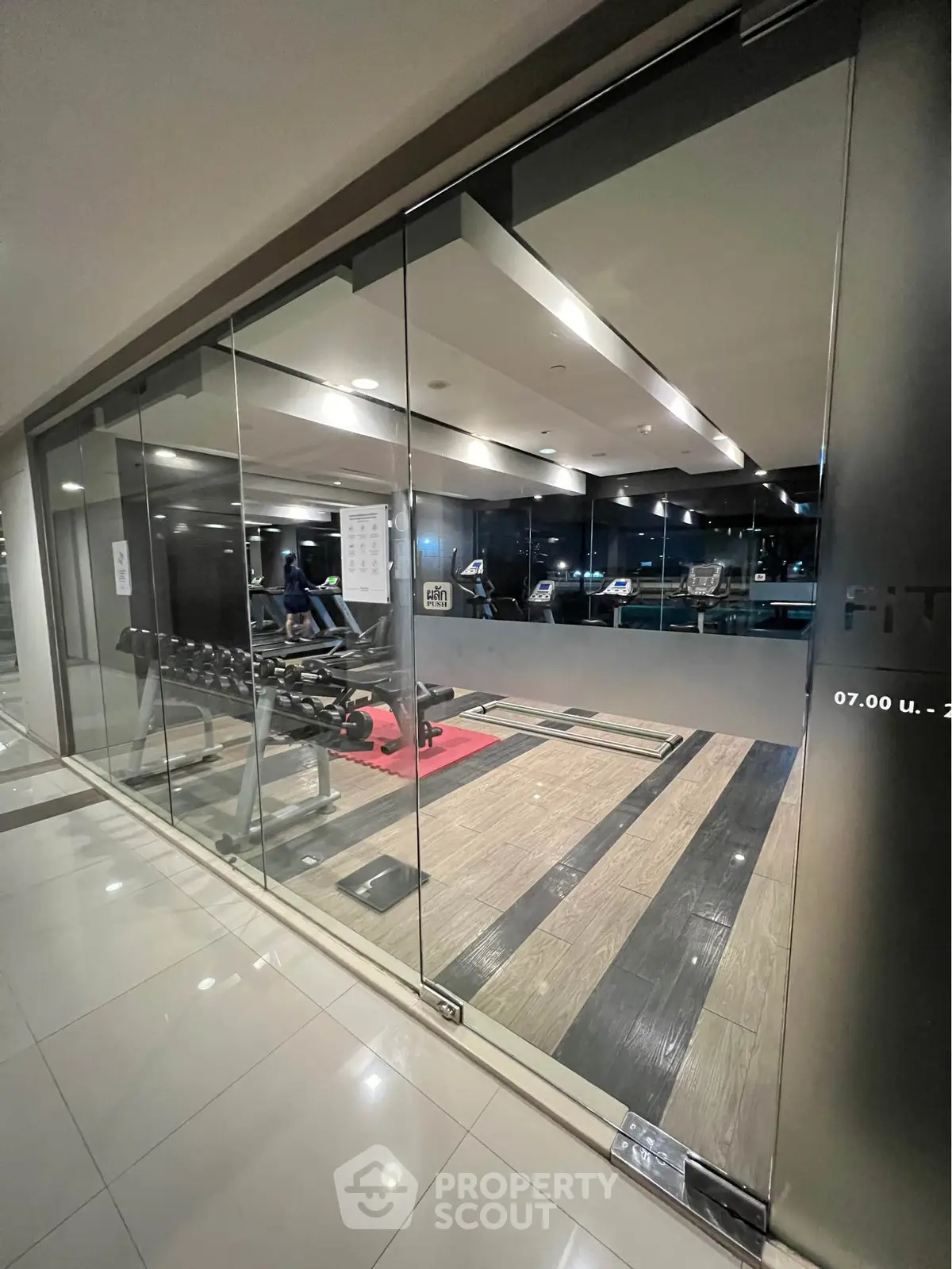 Modern gym with sleek glass walls and state-of-the-art fitness equipment.