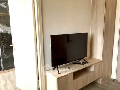Modern living room with sleek TV setup and stylish wooden furniture.