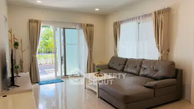 Spacious living room with modern decor and large sliding glass doors leading to a garden view.