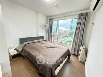 Cozy bedroom with large window and modern decor in urban apartment