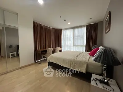 Spacious bedroom with elegant decor and large window for natural light