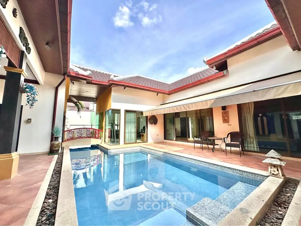Luxurious villa with private pool and spacious patio under clear blue sky.