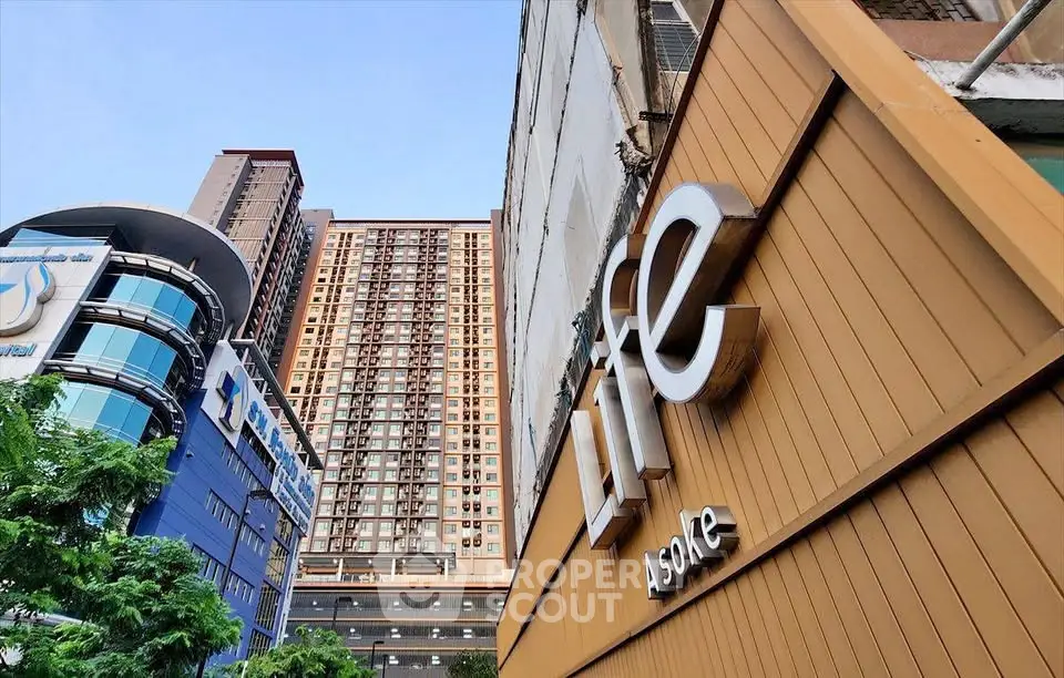 Modern high-rise building exterior with sleek design and prominent signage in urban setting.
