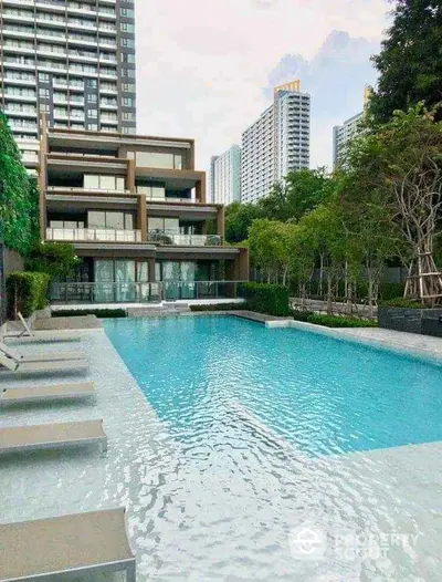 Luxurious residential building with a stunning pool and lush greenery, perfect for modern urban living.