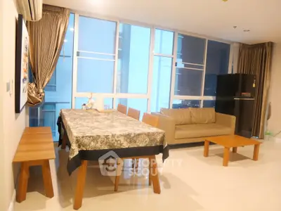 Spacious living room with modern furniture and large windows offering city views.
