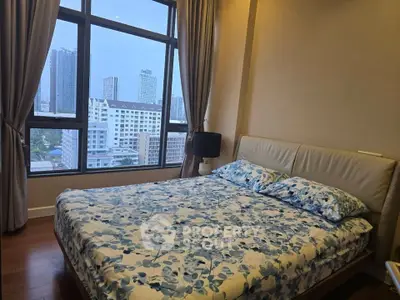 Cozy bedroom with large window offering stunning city views, featuring a comfortable bed and elegant decor.