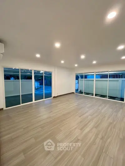 Spacious modern living room with large windows and elegant flooring