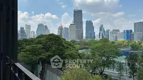 Stunning cityscape view from a balcony overlooking lush greenery and skyscrapers.