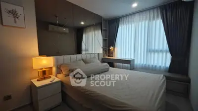Modern bedroom with stylish decor and large window for natural light.