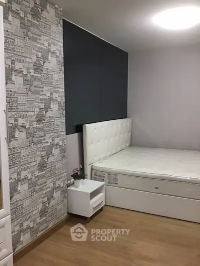 Modern bedroom with stylish wallpaper and elegant bed design.