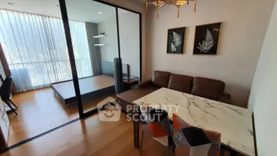 Modern living room with glass partition and stylish decor in a high-rise apartment.