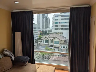 Spacious living room with large window offering stunning city view