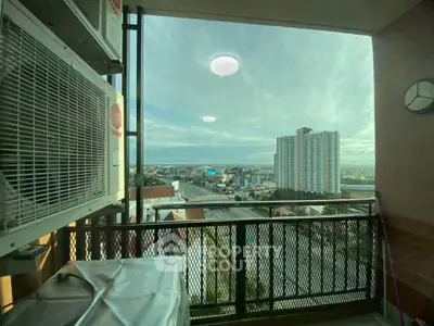Stunning city view from a high-rise balcony with modern air conditioning unit.