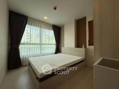 Spacious bedroom with large windows and modern decor in a stylish apartment.