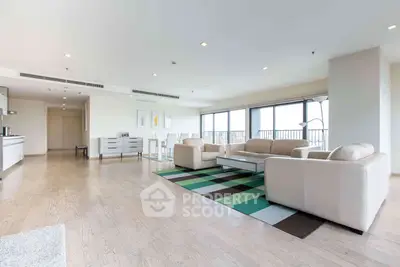 Spacious modern living room with open layout and large windows offering natural light