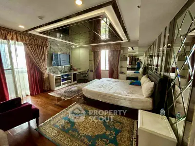 Luxurious bedroom with mirrored ceiling and elegant decor in a modern apartment.
