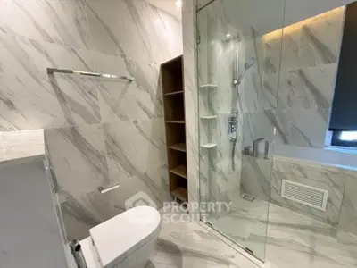 Luxurious modern bathroom with marble tiles and glass shower enclosure