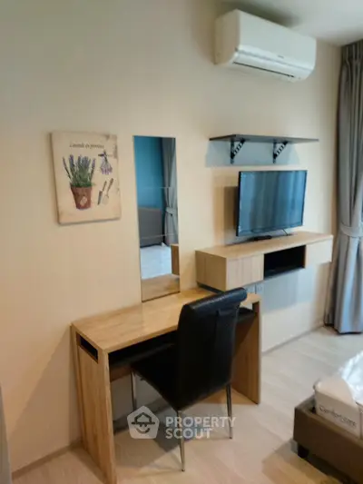 Modern bedroom with sleek desk, wall-mounted TV, and air conditioning for comfort and style.