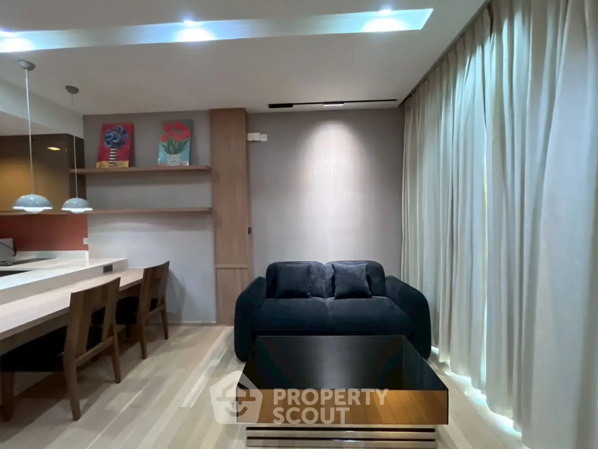 Modern living room with stylish decor and open layout, featuring a cozy sofa and elegant dining area.