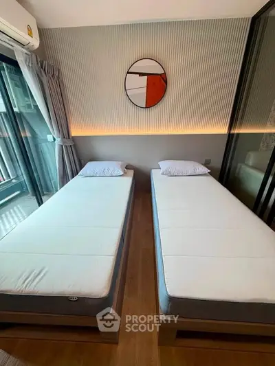 Modern bedroom with twin beds and stylish decor in a contemporary apartment.