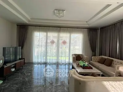 Spacious living room with elegant decor and large windows offering natural light.