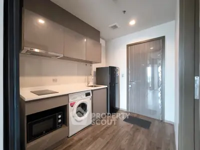 Modern kitchen with sleek appliances and wood flooring