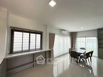 Spacious modern dining area with large windows and elegant furnishings