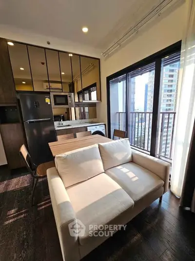 Modern living room with open kitchen and city view from balcony.