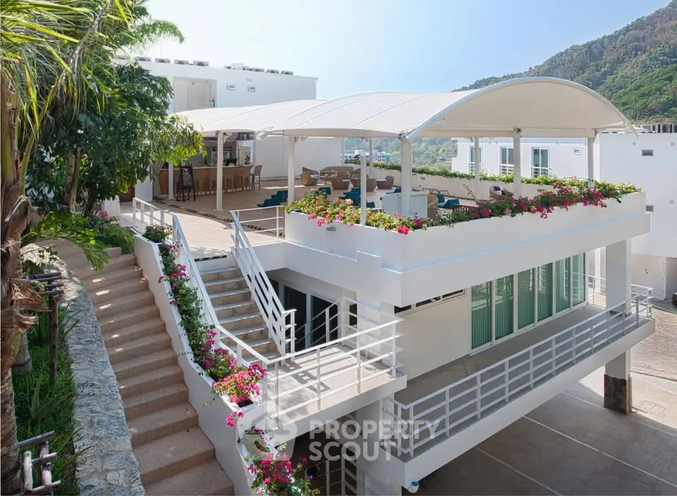 Stunning modern building with spacious terrace and vibrant floral decor