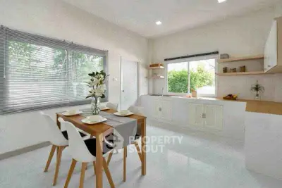 Spacious kitchen with dining area, featuring modern white cabinetry and large windows for natural light.