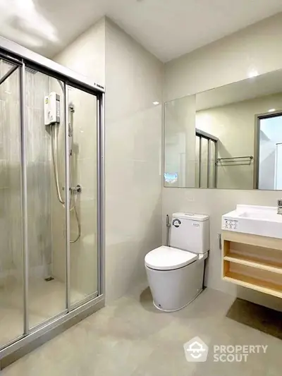 Modern bathroom with glass shower and sleek fixtures in a contemporary apartment.