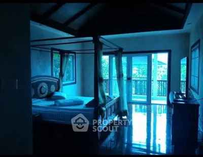 Luxurious bedroom with canopy bed and balcony view