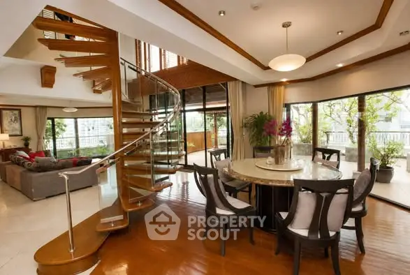 Luxurious living room with spiral staircase and large windows offering stunning views.