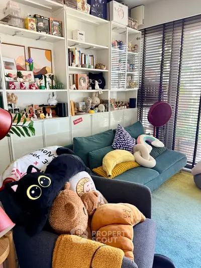 Charming living room with cozy seating, plush toys, and stylish shelving, perfect for relaxation and entertainment.