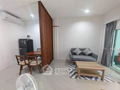 Modern living room with stylish furniture and open layout, featuring a cozy sofa and dining area.