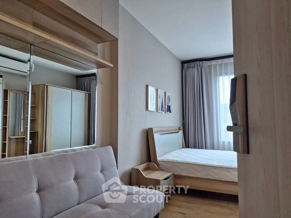 Modern bedroom with stylish decor and natural light, featuring a cozy bed and elegant furnishings.